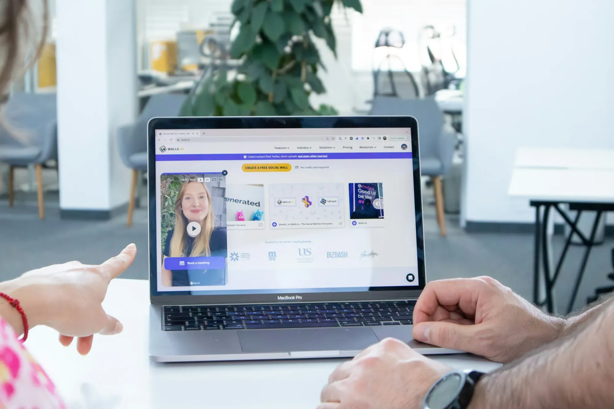 a man and a woman sitting in front of a laptop computer