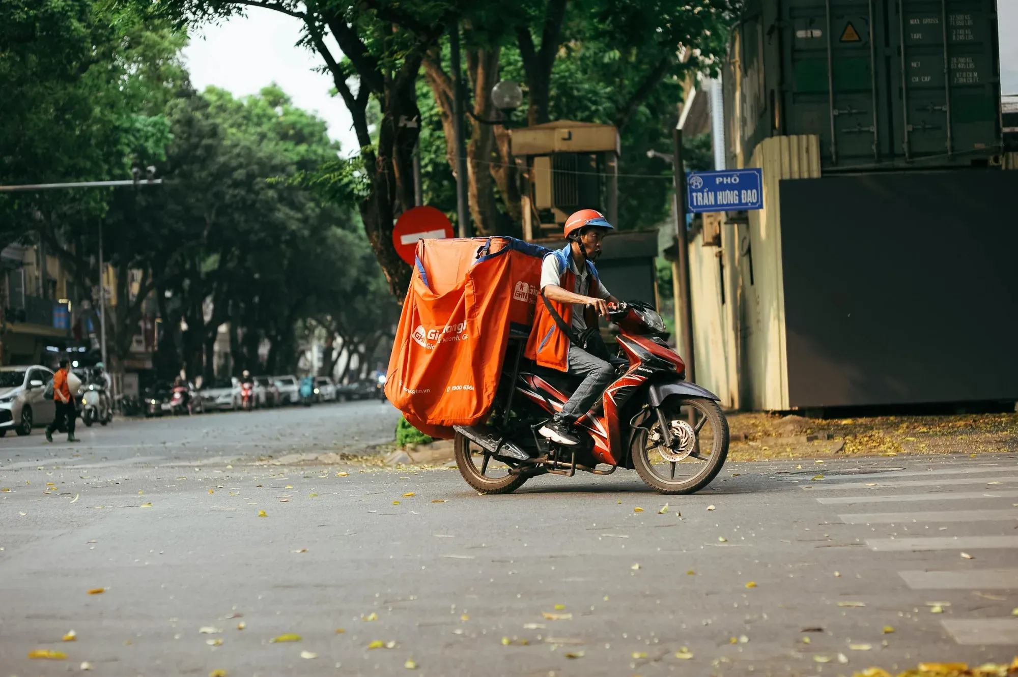 Un repartidor transporta mercancías en motocicleta en una concurrida calle de la ciudad.