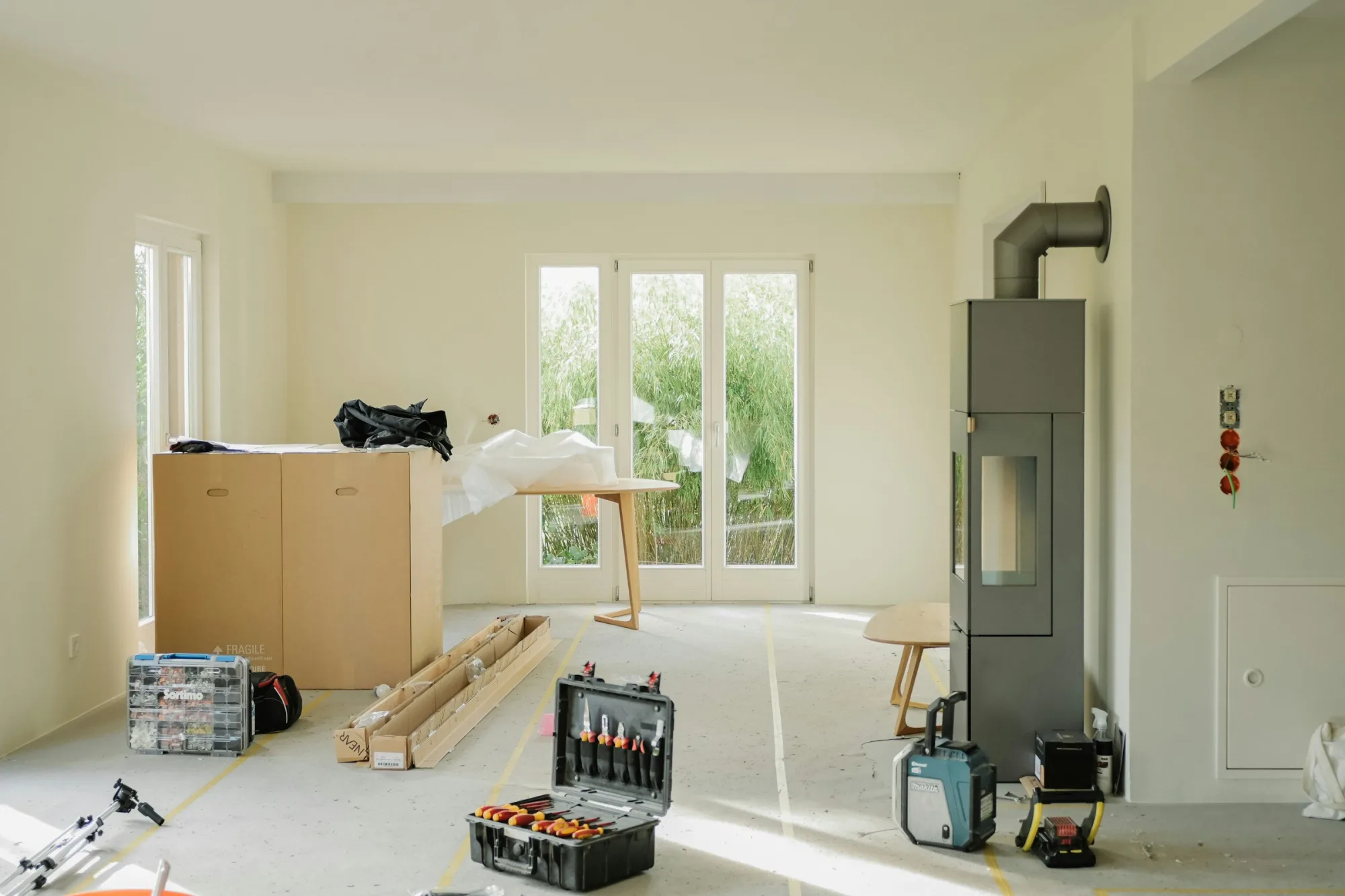 Room under renovation with tools and furniture.
