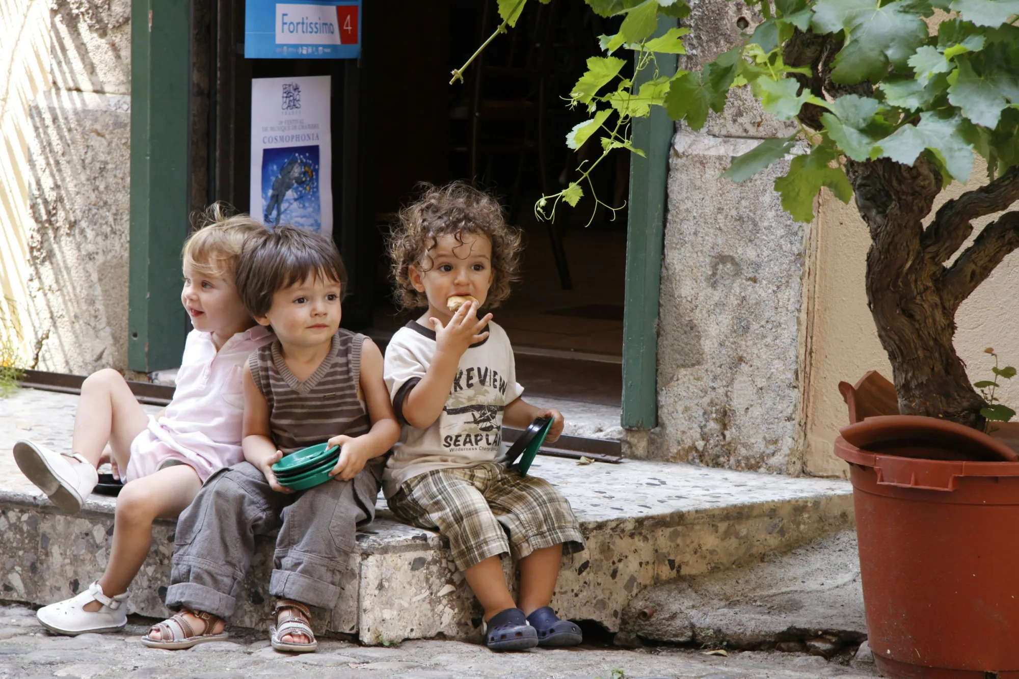 2 boys and girl sitting on concrete bench