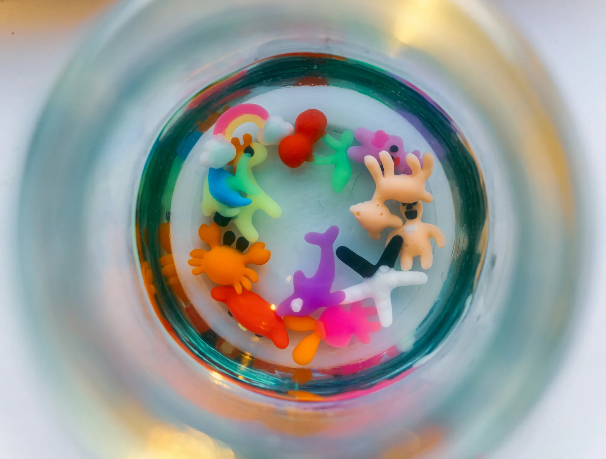 Colorful miniature figures arranged in a circle inside glass.