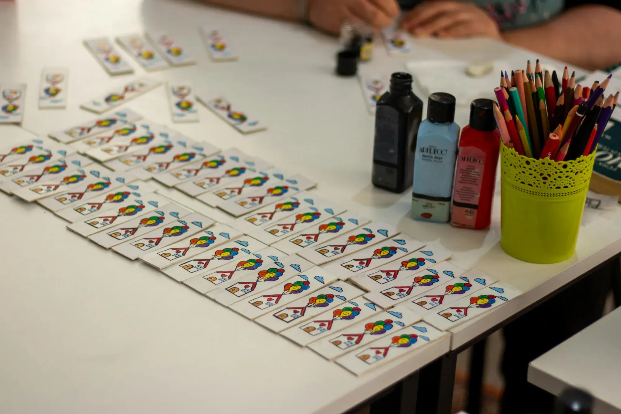 Configuración vibrante para manualidades con tarjetas DIY, con pintura y lápices en exhibición.