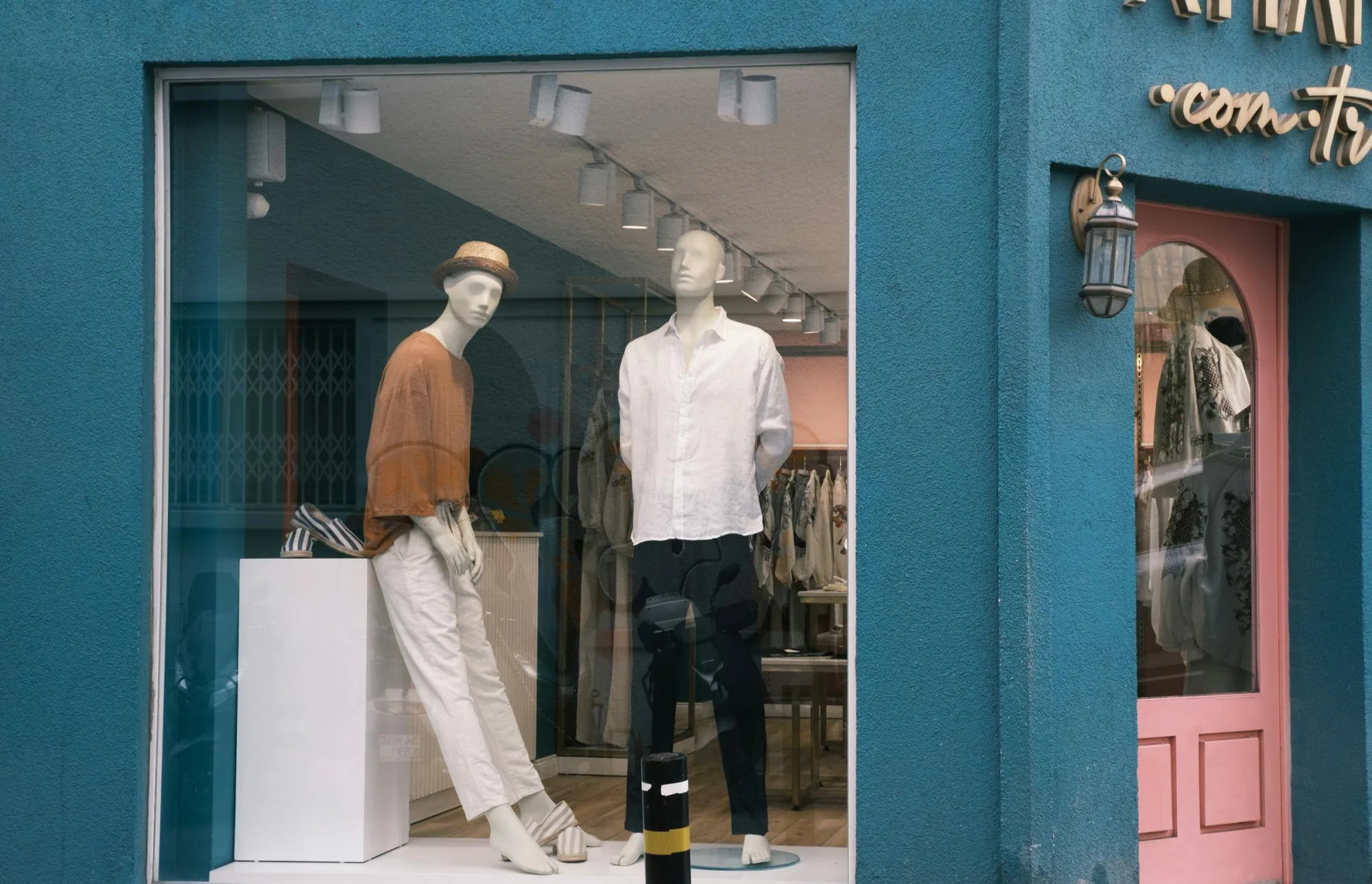 Maniquíes que exhiben prendas elegantes en el escaparate de una boutique.